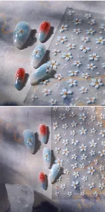 Dettaglio degli adesivi per unghie con fiori blu e motivi in rilievo dorati eleganti