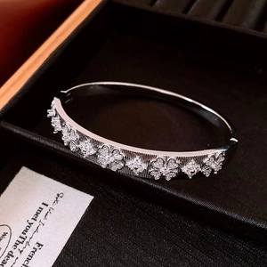 Bracelet trèfle argenté serti de diamants présenté dans un coffret à bijoux noir élégant
