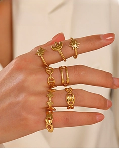 Close-up of gold stainless steel stackable rings with celestial and geometric patterns