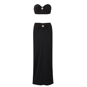 Detail of black two-piece set featuring golden swan metal buckles on top and long skirt