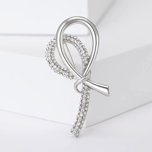 Elegant silver ribbon brooch with sparkling zircons on geometric display stands
