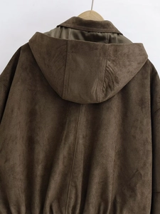 Detailed close-up of dark brown faux suede bomber jacket with olive green silk lining