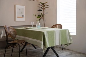 Detail of green and white striped rectangle cotton linen tablecloth with soft texture