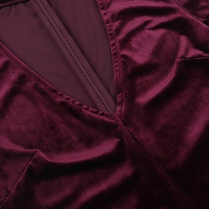 Detail of deep burgundy velvet jumpsuit with a V-neckline and invisible zipper closure