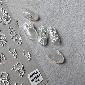 Detail of white embossed floral nail art stickers with intricate petal patterns
