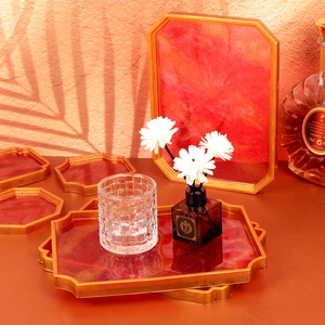 Detail view of red and gold resin coaster set and serving tray with vintage borders