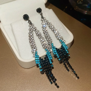 Gros plan de boucles d'oreilles à pampilles avec strass dégradés bleus et noirs