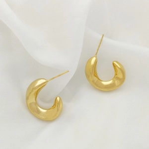 Elegant gold U-shaped chunky hoop earrings on a white silk background