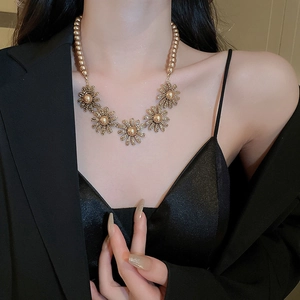 Elegant pearl and floral pendant necklace set showcased on a model in vintage style