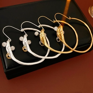 Detail of gold and silver textured hoop earrings with sparkling gemstone accents