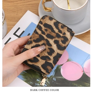 Close-up of leopard print card holder in dark coffee color with gold zipper detail