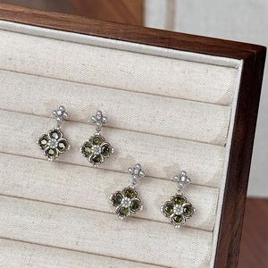 Macro view of vintage silver flower earrings with green zircon stones and white pearls
