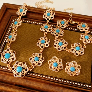 Detailed view of vintage gold floral jewelry set with turquoise gems and small crystals