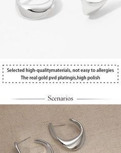 Détail de boucles d'oreilles argentées polies avec placage PVD or sur fond de lin
