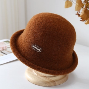 Close-up of deep brown wool felt cloche hat with leather patch detail and round crown