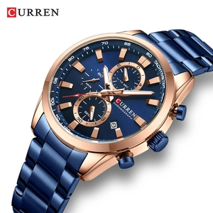 Detail shot of navy blue chronograph watch with rose gold case and date window