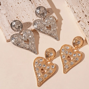 Exaggerated hammered metal heart earrings with rhinestones in gold and silver finish