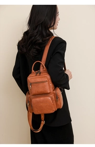 Side view of woman wearing a vintage brown PU leather backpack with multi-pocket design