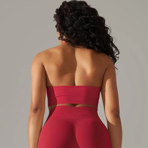 Detail of red seamless knitted yoga set featuring backless halter sports top and high waist leggings