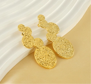 Detailed macro view of 18K gold-plated stainless steel earrings with lava ripple texture