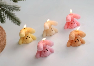Detail of colorful cartoon bear scented candles lit in a cozy festive setting