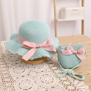 Détail de l'ensemble chapeau et sac en paille vert menthe avec nœuds roses brodés