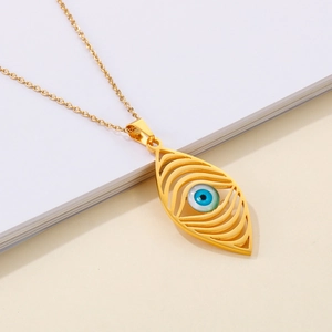 Bohemian gold stainless steel necklace featuring a minimalist evil eye pendant on a book