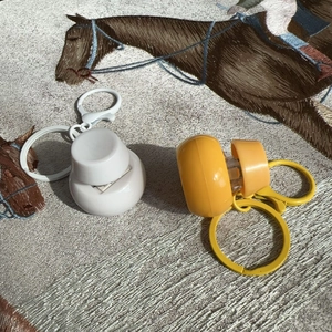 Close-up of portable fidget button keychains in white and yellow colors with clips