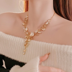 Detailansicht der luxuriösen goldenen Blumenhalskette mit Kristallen am Model