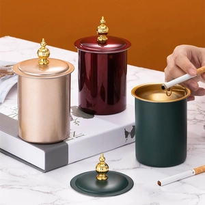 Three elegant cylindrical metal storage jars with gold knobs shown in a lifestyle scene