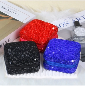 Macro shot of three luxury rhinestone jewelry boxes in red, black, and blue finishes