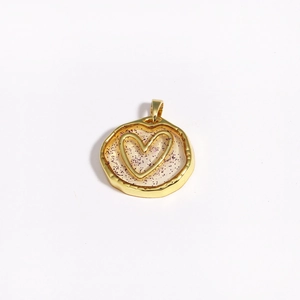 Detail of a golden irregular resin pendant with purple glitter and a 3D heart center