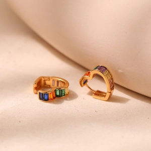 Detail view of heart-shaped gold hoops with colorful rectangular-cut rainbow zircon stones