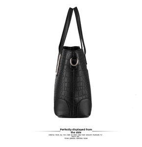 Side profile of black crocodile pattern faux leather tote bag with round metal hardware