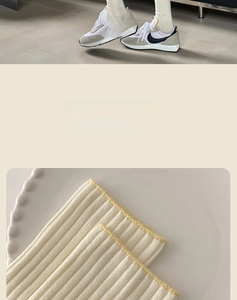 Detailed view of cream-white cotton blend socks featuring vertical ribbed knit and yellow trim