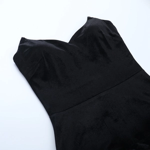 Detail of a black velvet mini dress featuring a sweetheart neckline and plush feather hem