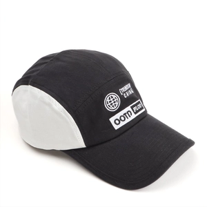 Close-up of five-panel camper hat with white 3D embroidery and black canvas brim