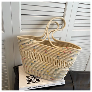 Detailed view of woven tote bag with colorful dots on a textured cotton rope surface
