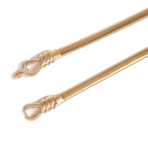 Detailed macro view of a gold metallic elastic waist chain with a knotted buckle design