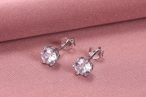 Macro detail of S925 sterling silver stamp on classic six-prong zircon stud earrings