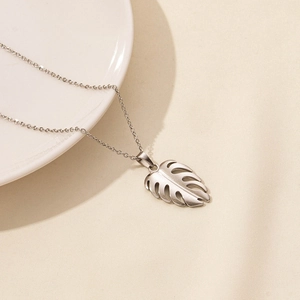 Detailed close-up of silver monstera leaf pendant with matte finish on O-chain necklace