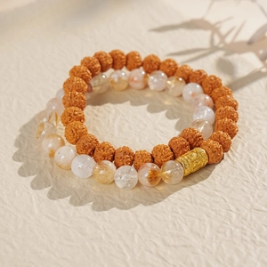 Macro shot of double-layered Bodhi beads and transparent golden rutilated quartz bracelets