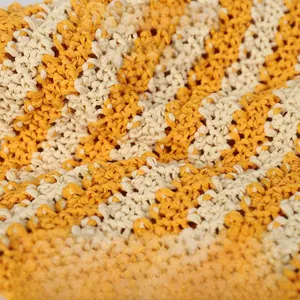 Detail macro view showing the yellow and cream striped texture of handmade knitted hat