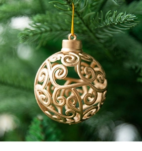 Detailed view of a golden hollowed Christmas ball with spiral patterns on tree branches