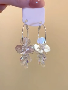 Détails de boucles d'oreilles fleur argentée avec cristaux et pendentifs irisés