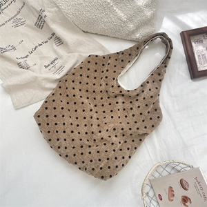 Close-up of brown polka dot corduroy tote bag with spacious interior and soft white lining