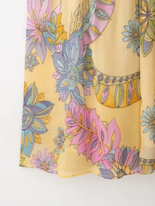Dettaglio del tessuto in chiffon giallo con stampa floreale e trama traslucida