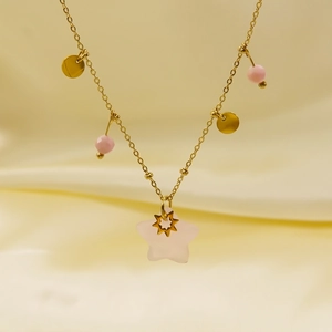 Detail of star pendant necklace with pink natural stone and gold beads on silk