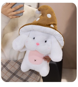 Gros plan d'un lapin en peluche blanc portant un chapeau champignon marron à pois