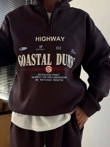 Détail d'un sweat à col zippé en coton marron foncé avec imprimés rétro Highway